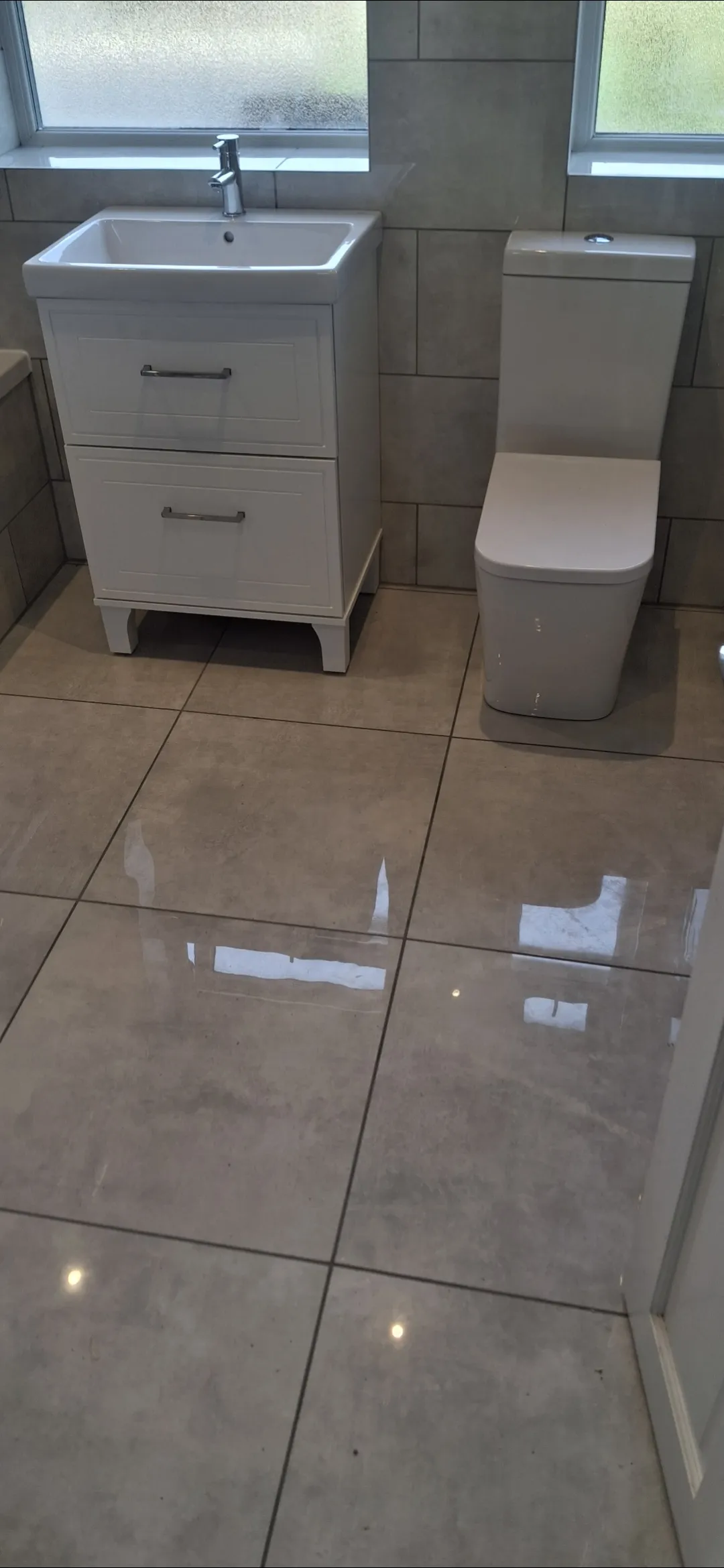 Bathroom beige large tile with white vanity and toilet completed — bathroom fitters Surrey