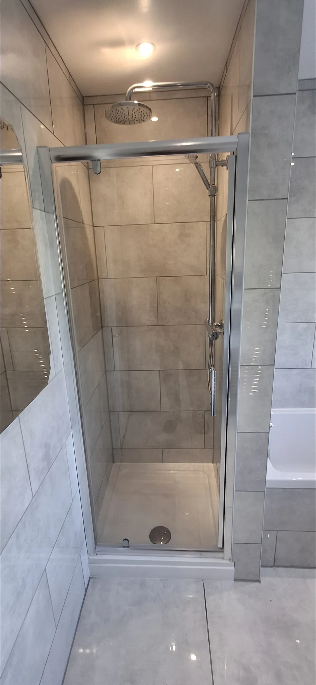 Bathroom beige tile shower enclosure with rainfall shower head — bathroom tilers Surrey