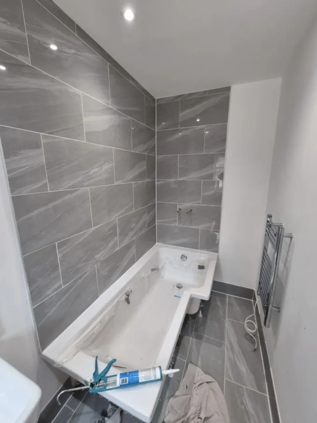 Bathroom grey marble tiles with bath fitting in progress — bathroom fitters Surrey