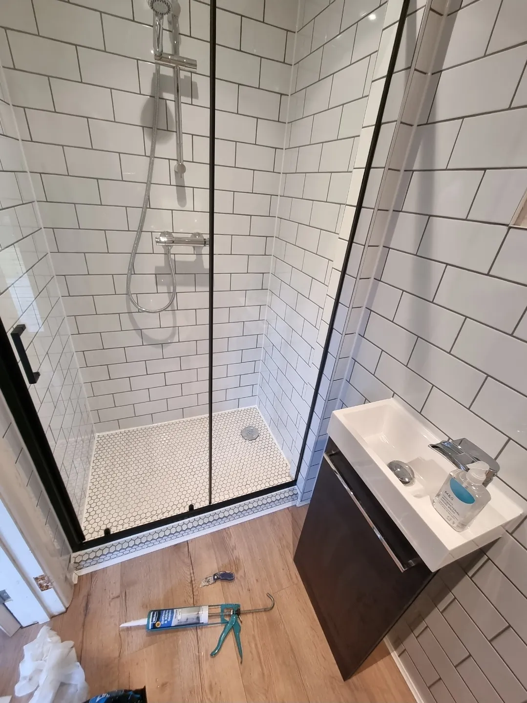 Bathroom white metro tile shower with black frame door and vanity unit — bathroom renovation Surrey