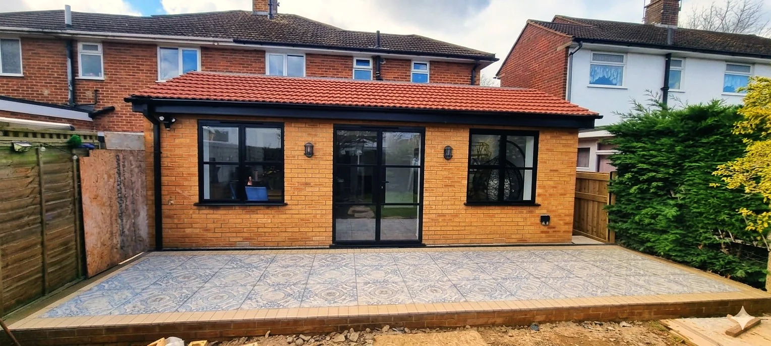 Completed rear extension with golden brick, bifold doors and decorative patio — extension builders SW London